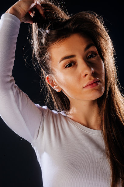 一个有吸引力的女孩的肖像，她的头发，而看起来英俊和满足。图片下载