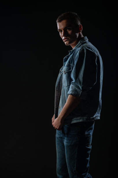 照片中的年轻英俊男子与腹肌和开放的牛仔夹克和牛仔裤。图片下载