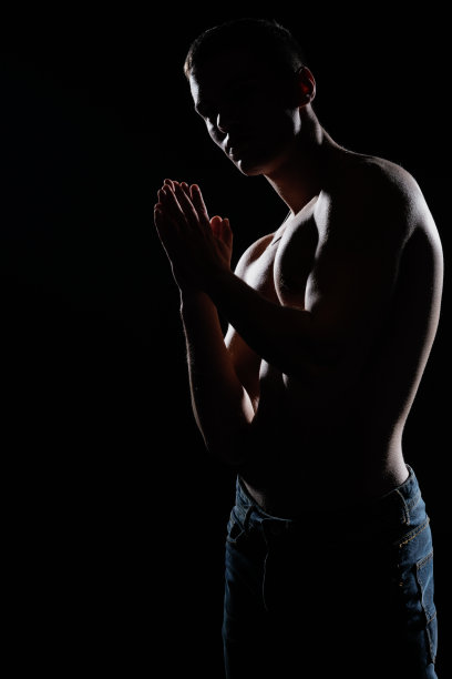 高对比剪影肖像的性感年轻男性模特赤膊摆姿势在一边。图片下载