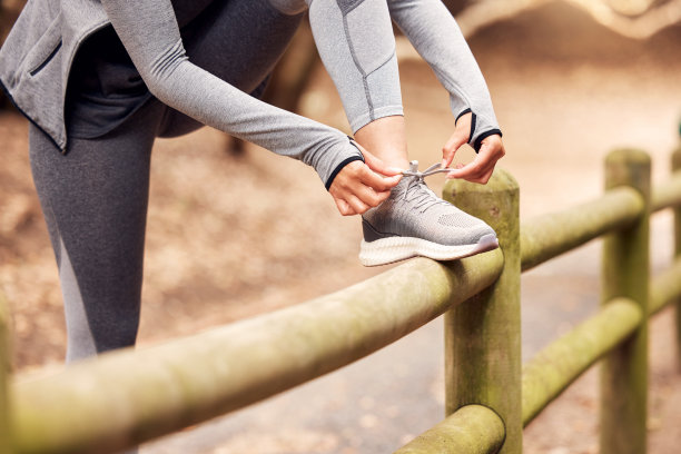 这张照片拍摄的是一个不知名的女人在去大自然中跑步前系鞋带图片下载