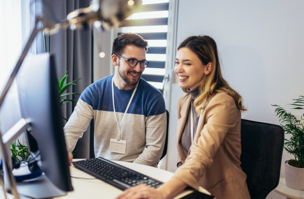 一对年轻夫妇，一男一女，坐在家里的桌子旁，一起用电脑工作图片下载
