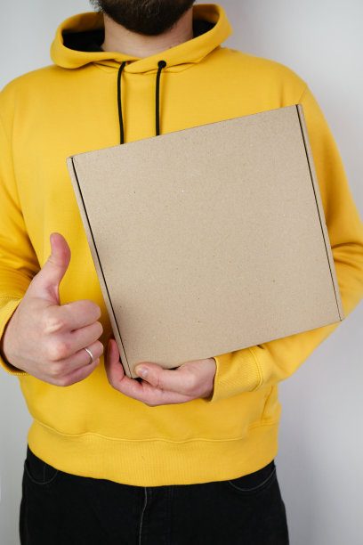 一个男人手里拿着一个纸盒。有新包裹的人。邮政服务,交货。牛皮纸。礼物盒,礼物。盒子特写。空包装，空空间。沟通的人。纸箱图片下载