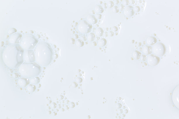 宏观牛奶，白色的牛奶表面和泡沫和涟漪从上面鸟瞰，泡沫在牛奶表面图片下载