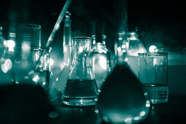 在实验室用溶液测试玻璃烧瓶。科学和医学背景。实验室试管暗色调背景，科研设备概念图片下载