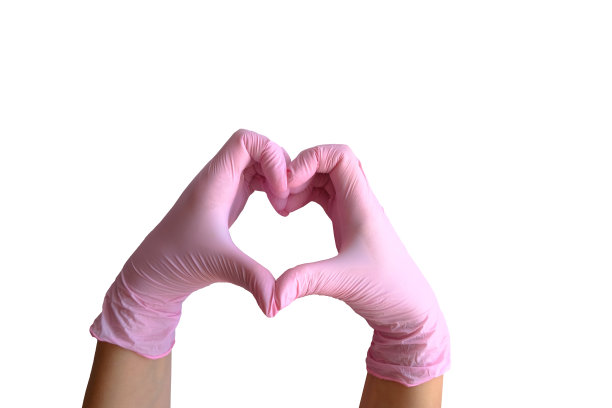 女人戴着橡胶粉色手套的手在白色背景上显示出一个心形的标志，并留出一个复制空间图片下载