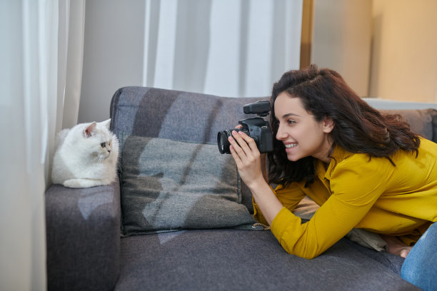年轻的女摄影师拍摄照片和看参与图片下载