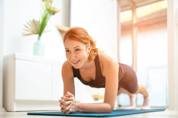 美丽的姜女人在运动垫在家里在平板位置工作。家庭，锻炼，女人，训练，瑜伽，普拉提，俯卧撑，平板，向上，锻炼，腹部，健身房，房子，活跃，手臂，健康，运动，腹部，肌肉，初学者图片下载