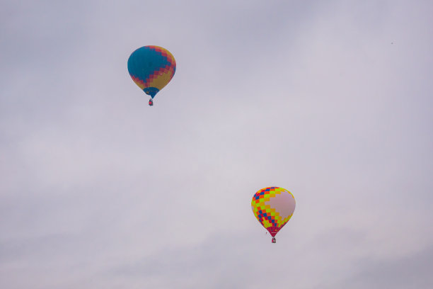 两个彩色的热气球在灰色的天空中飞翔图片下载