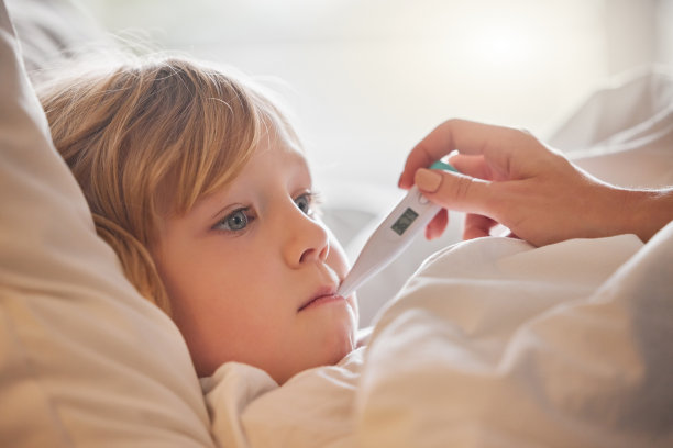 这张照片拍摄的是一个陌生的女人在家里的床上用体温计给一个小女孩量体温图片下载