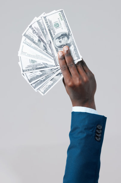 一名不知名的商人在灰色背景下炫耀美元图片下载