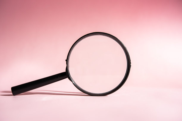 一个黑色的放大镜，粉红色的背景，搜索，研究，寻找的概念。图片下载