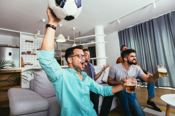 兴奋的朋友在看足球比赛，拿着啤酒和爆米花图片下载