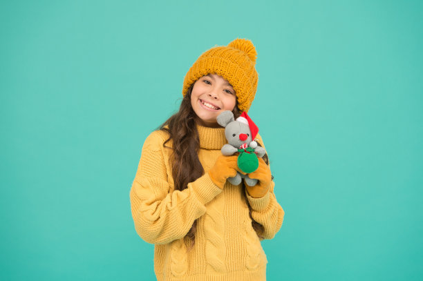 快乐的童年。毛绒玩具是最好的。冬装小孩玩可爱的小玩具。买礼物。幼儿园和学校。玩具商店的概念。女孩抱着老鼠或老鼠玩具。鼠年象征。毛绒玩具图片下载