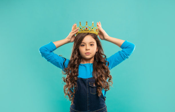 王冠上的自私孩子。自信的女王。表达沾沾自喜。傲慢的公主戴着皇冠。图片下载