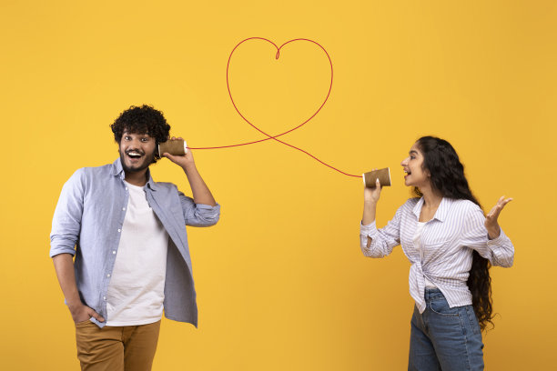 爱的歌。深情的印度女士发送浪漫的信息，她的男朋友通过锡电话，黄色的背景图片下载