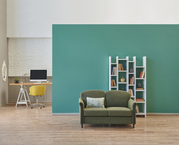 绿色墙壁的房间，工作台和电脑，书架沙发与植物的室内风格。图片下载