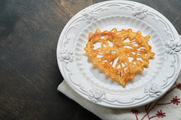 心形花边煎饼或薄饼在白色的盘子上古老的乡村背景。为你最喜欢的情人节早餐布置餐桌。俯视图复制空间。图片下载