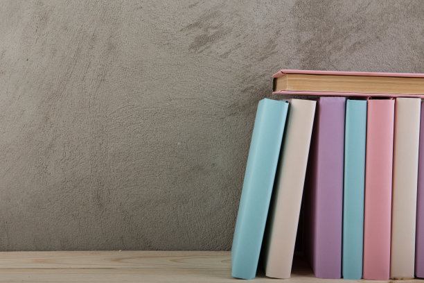 教育和阅读的概念-木桌上的彩色书籍组，混凝土墙壁上的黑板图片下载