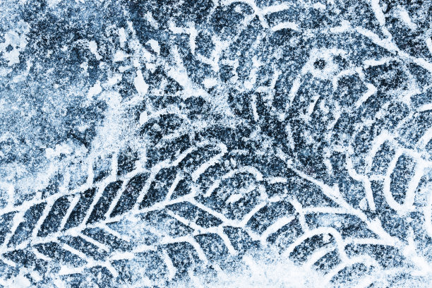 雪地轮胎。被雪覆盖的沥青。危险的道路状况。图片下载