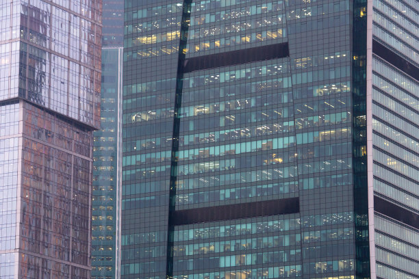 商务中心的窗户是由玻璃和金属制成的。未来的建筑。许多办公室都是玻璃做的。两个现代化的办公大楼细节与透明的玻璃墙。图片下载