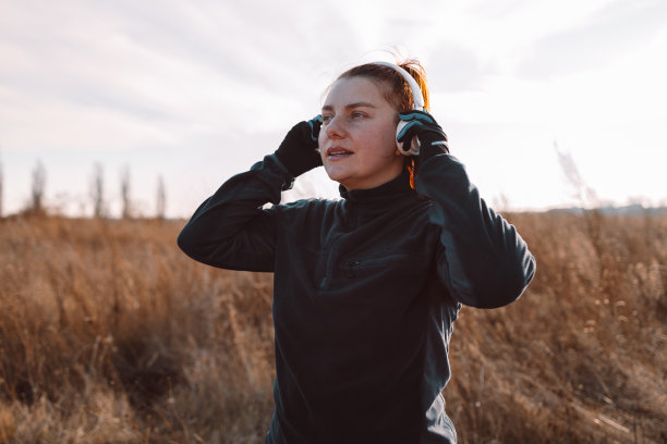 一大早戴着耳机的快乐女人在公园外面慢跑，享受着积极健康的生活图片下载