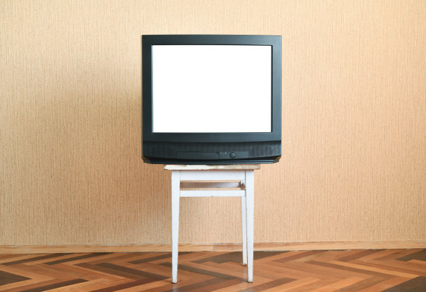 旧的白色屏幕电视放在旧的椅子上，旧的房子设计在20世纪80年代和90年代的风格。图片下载