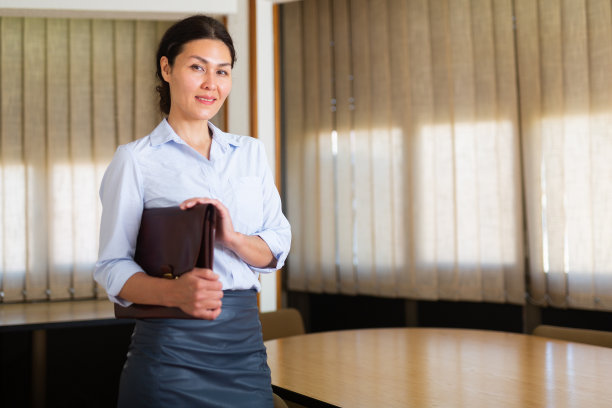 自信的亚洲女商人站在会议室拿着公文包图片下载