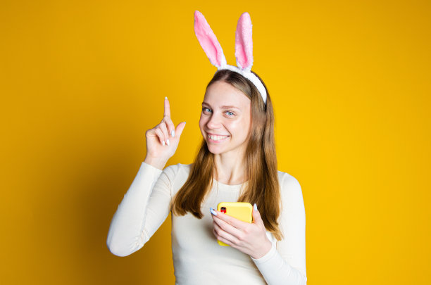 一个金发女孩手里拿着一部黄色手机，正在打印信息图片下载