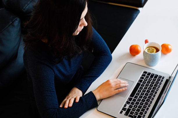 这个女孩喝着橘子茶，在电脑前工作图片下载