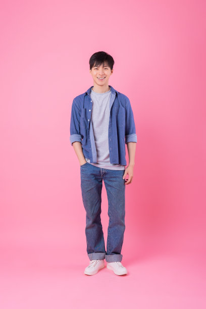 年轻的亚洲人在粉红色的背景上摆姿势图片下载