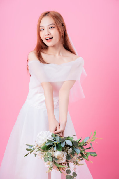 年轻的亚洲新娘在粉红色的背景上摆姿势图片下载