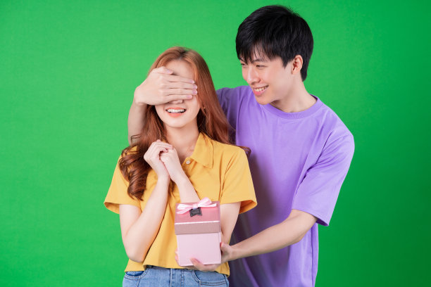 年轻的亚洲夫妇在绿色的背景上摆姿势图片下载