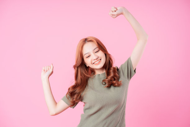 年轻的亚洲妇女在粉红色的背景上摆姿势图片下载