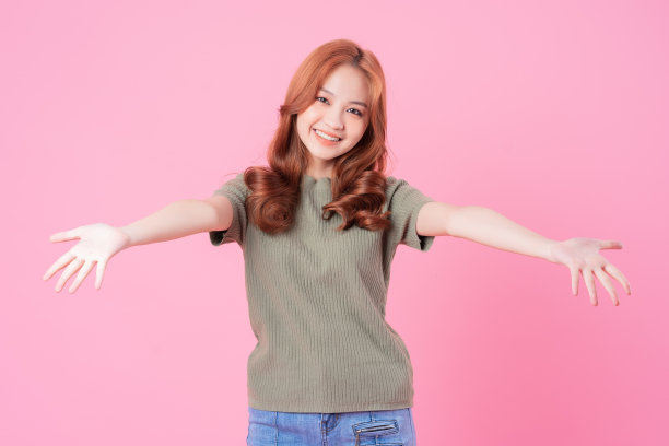 年轻的亚洲妇女在粉红色的背景上摆姿势图片下载