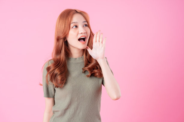 年轻的亚洲妇女在粉红色的背景上摆姿势图片下载