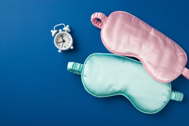 俯视图照片的小白色警报和两个丝绸面具粉红色和浅蓝色一个在漂亮的深蓝背景copyspace图片下载