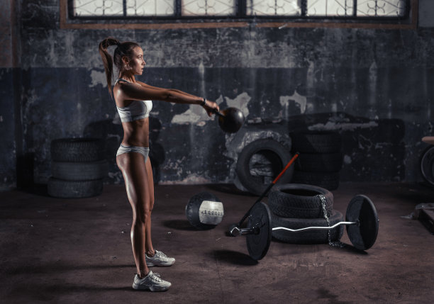 体育馆的壶铃训练，旧车库的女人锻炼。图片下载