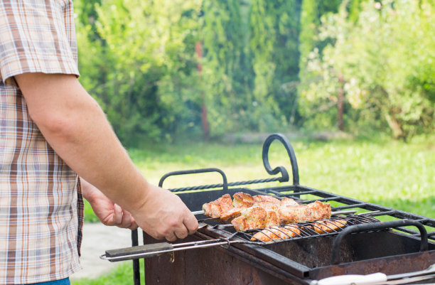 夏天，一个男人在花园里烧烤图片下载