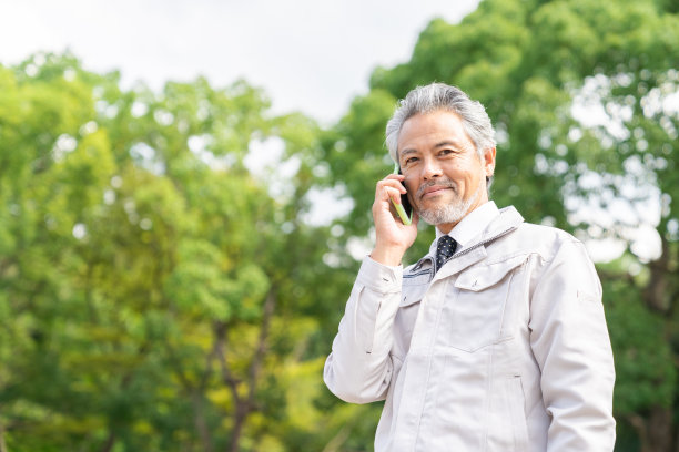 资深亚洲商人，建筑工人，在电话中交谈图片下载