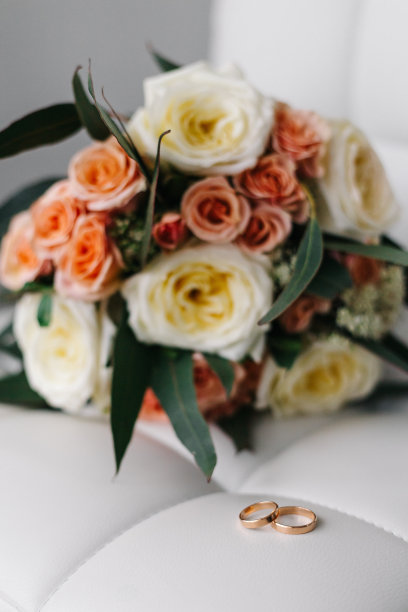 精致的婚礼花束，米色和粉红色的玫瑰和结婚戒指。图片下载