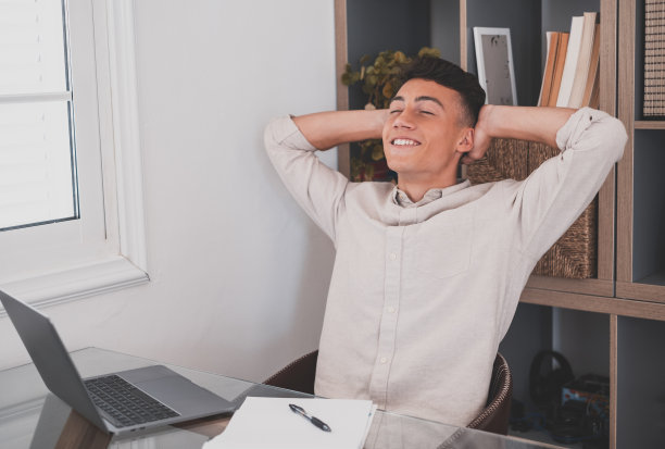 快乐满意的白种人休息在家里办公室坐着手提电脑手放在脑后，梦想的少年放松完成工作感到安心看向远方梦想思考未来成功的概念图片下载