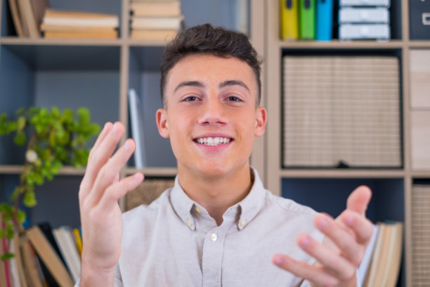 大头照肖像自信的商人教练戴着眼镜看着镜头和谈话，导师演讲者拿着在线课程，解释，坐在木制的工作桌在现代橱柜图片下载