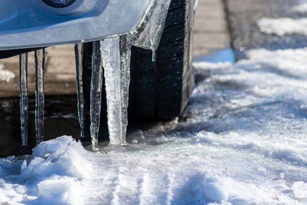 挂在有轮胎的汽车上的长条形冰柱，显示出在极端低温的暴风雪后滑滑的街道，这是冬季城市驾驶问题，需要为汽车购买冰和霜冻天保险图片下载