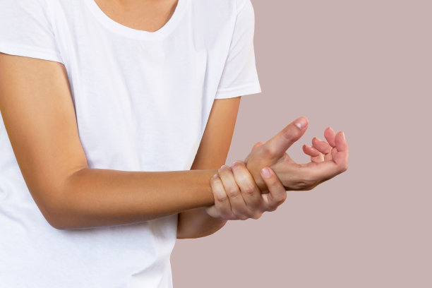 一个年轻的女人握着她的手腕。手腕受伤，手臂疼痛，腕管综合症，神经痛图片下载
