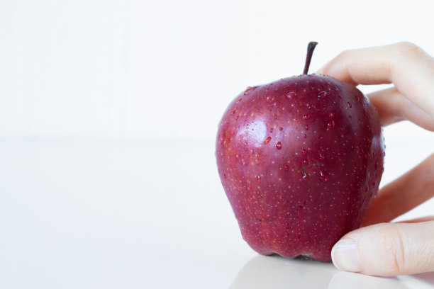 女人的手握有机多汁的红美味苹果孤立在白色背景与复制空间图片下载