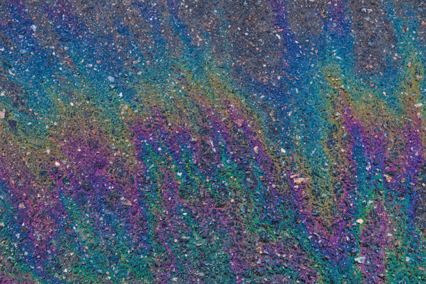 石油、天然气或汽油在沥青上形成彩虹图片下载