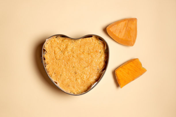 在家做心形蛋糕。在米色的背景上切南瓜和心形面团。循序渐进的照片说明。步骤1图片下载