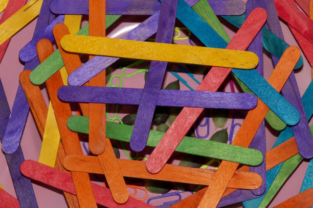 在他们下面的粉色盘子上有一排五颜六色的冰淇淋棒，上面是粉色背景上的花朵图案图片下载