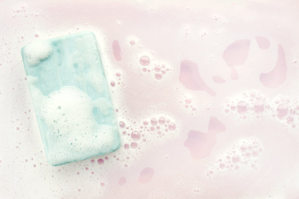 肥皂条和泡沫粉红色的背景，俯视图。模型设计图片下载
