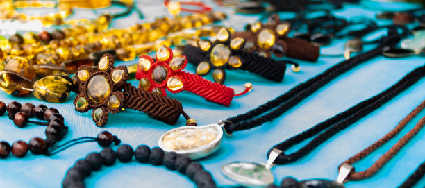 在公园附近的街道上，一个拉丁美洲男性工匠在一个摊位上制作手工制品图片下载